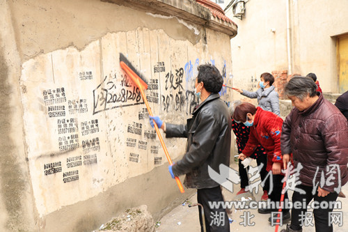群眾自發(fā)清理亂貼亂畫小廣告.jpg