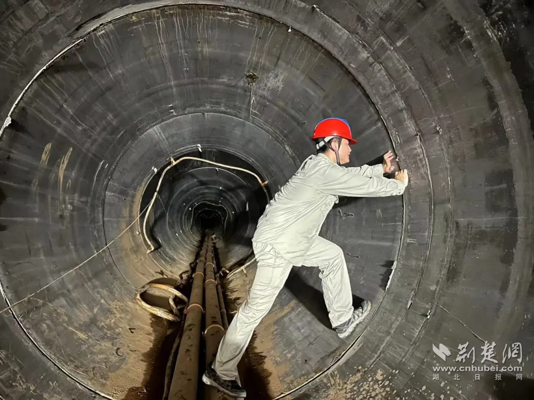 圖2：湖北送變電公司員王明陽(yáng)在隧道內(nèi)檢查頂管接頭情況，確保節(jié)日期間施工安全質(zhì)量。.png.png
