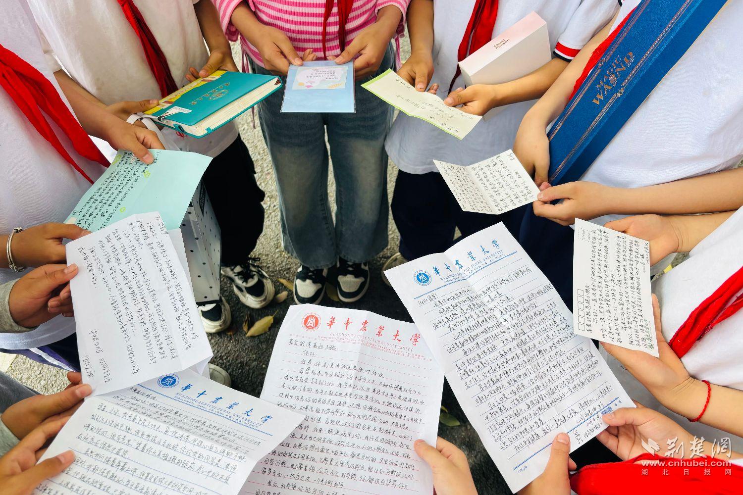 羅家壩小學的孩子們展示華農志愿者書信(通訊員 黃龍倩 攝).jpg.jpg