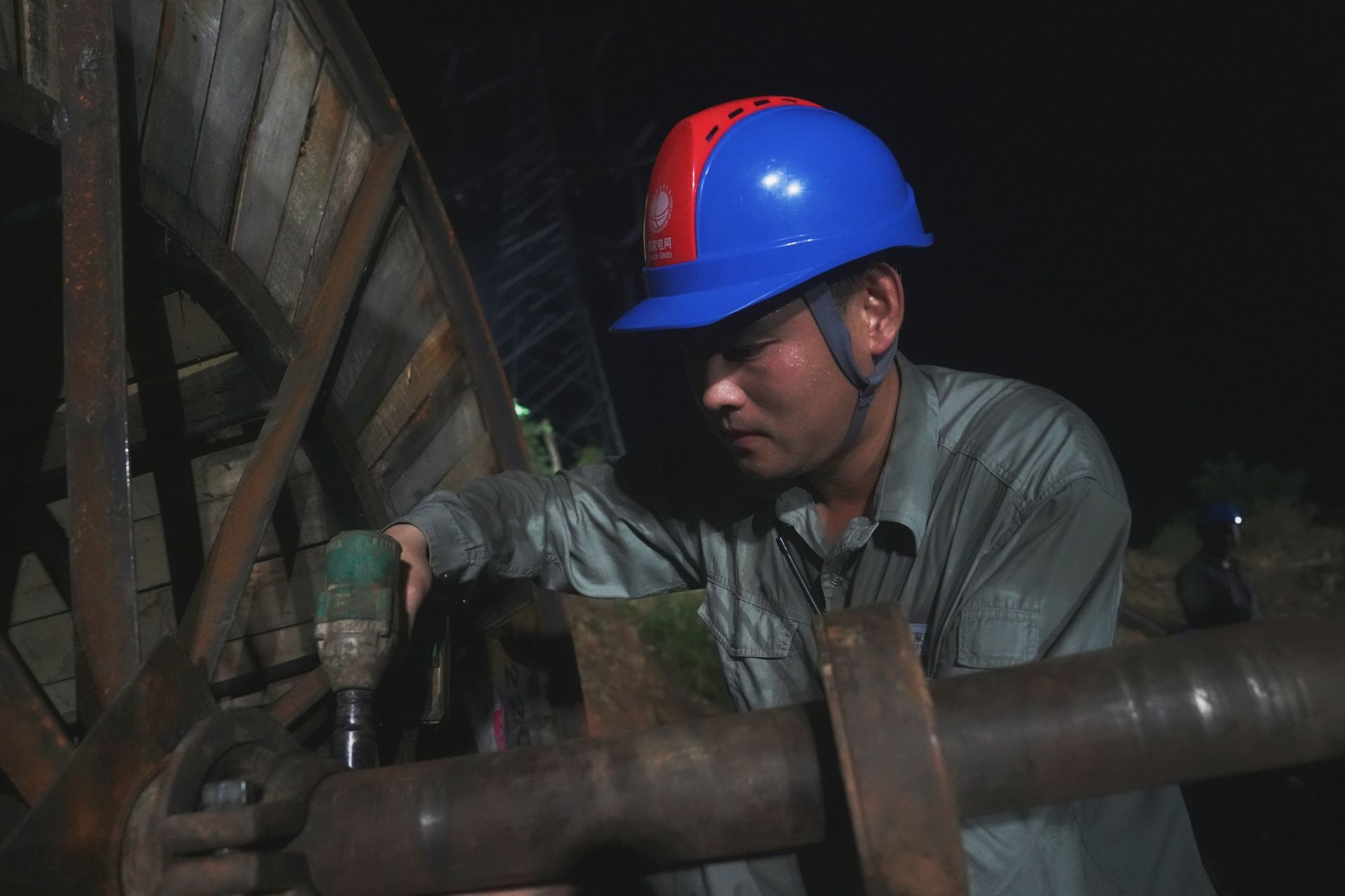 圖6：7月9日凌晨1時16分，湖北蒲圻電廠三期-赤壁500千伏線路工程跨越施工現場，國網湖北送變電公司員工姜夢迪 安裝尾車軸。（