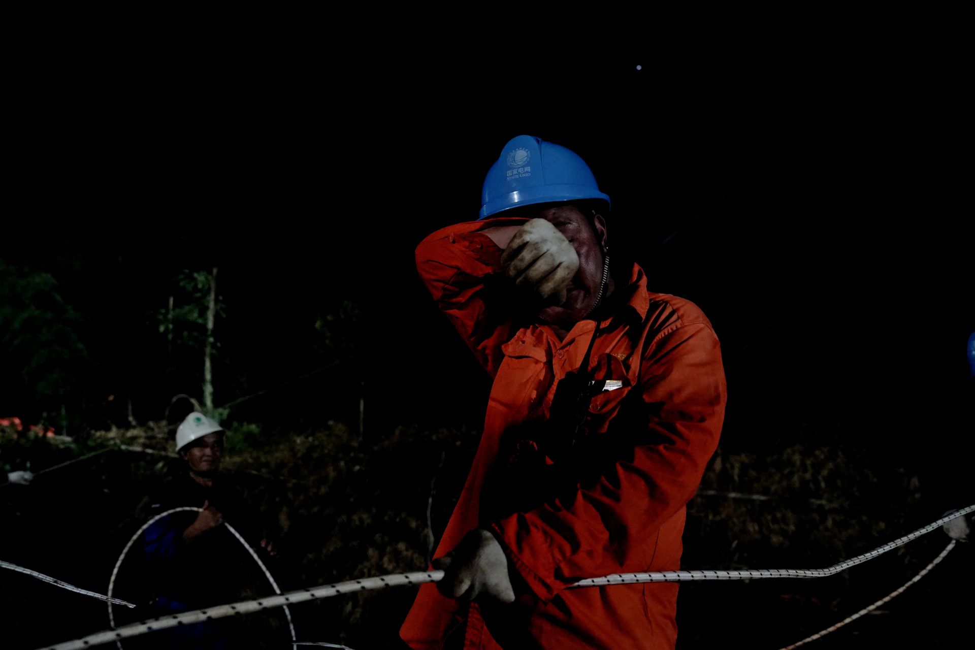 圖8：7月9日凌晨1時16分，湖北蒲圻電廠三期-赤壁500千伏線路工程跨越施工現場，國網湖北送變電公司員工在擦汗。（郭暉）.JP